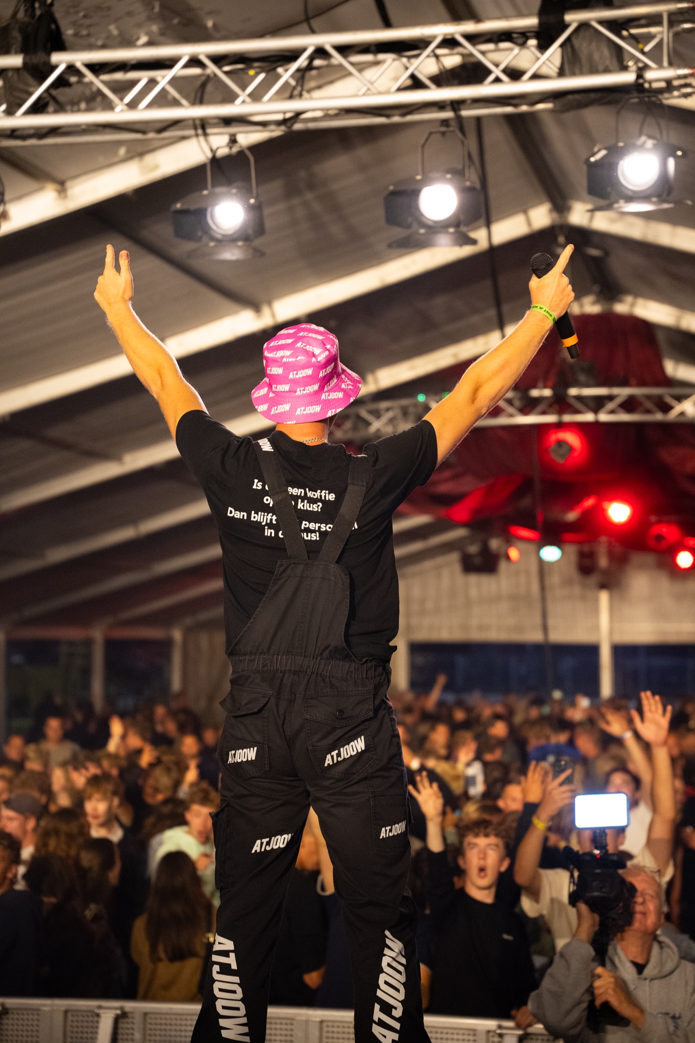 Artist from behind with arms raised toward the crowd
