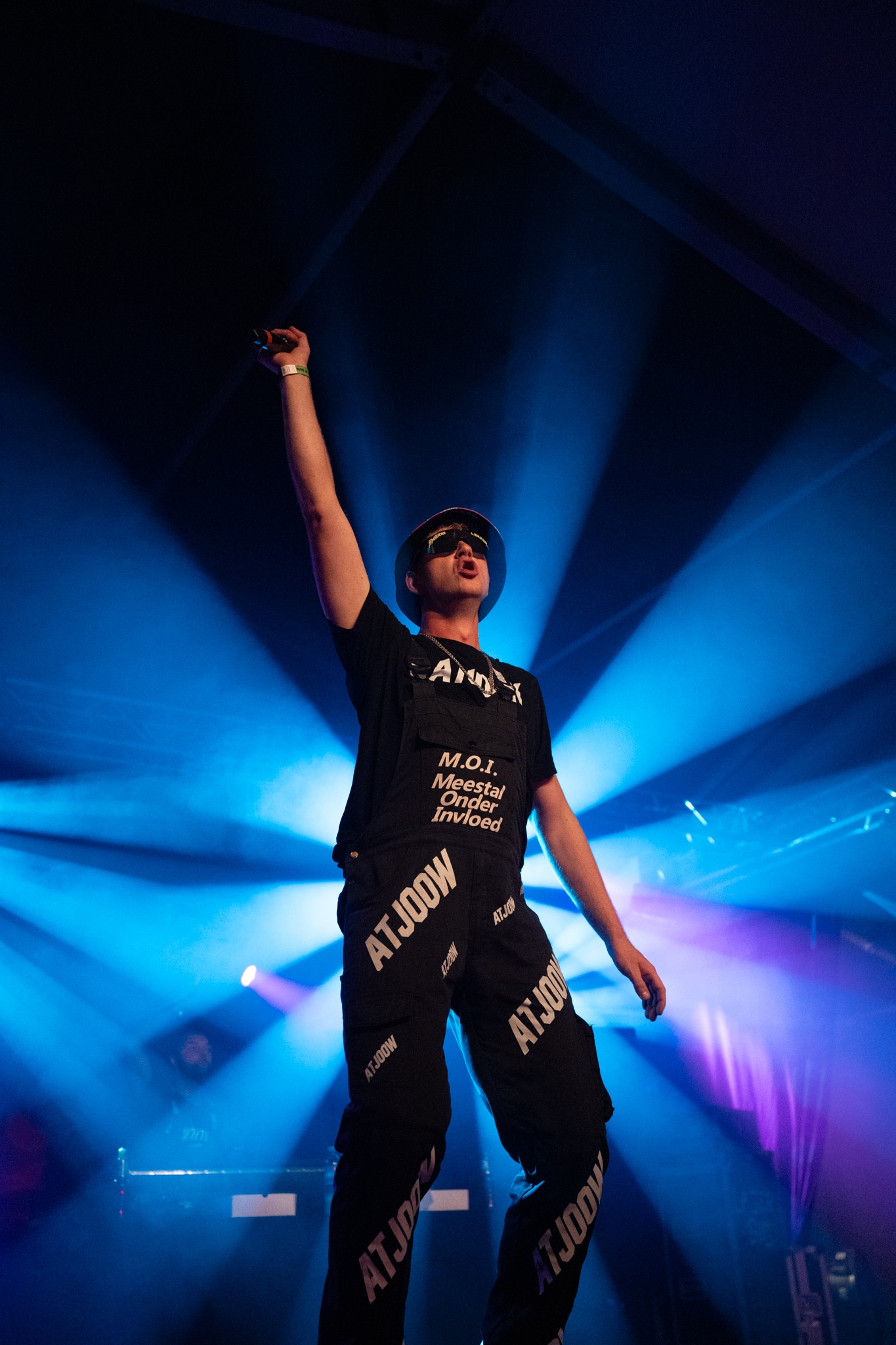 Performer under blue spotlights with microphone raised