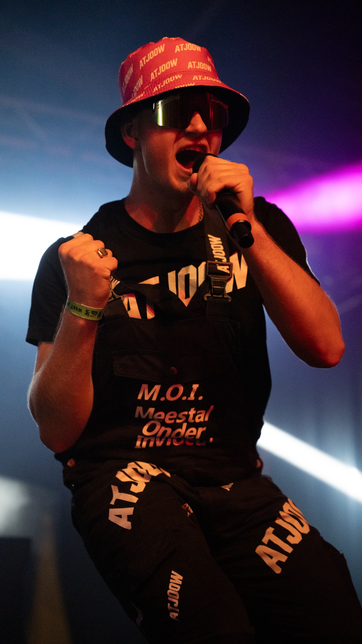 Performer in a red ATJOOW hat with fist clenched on stage