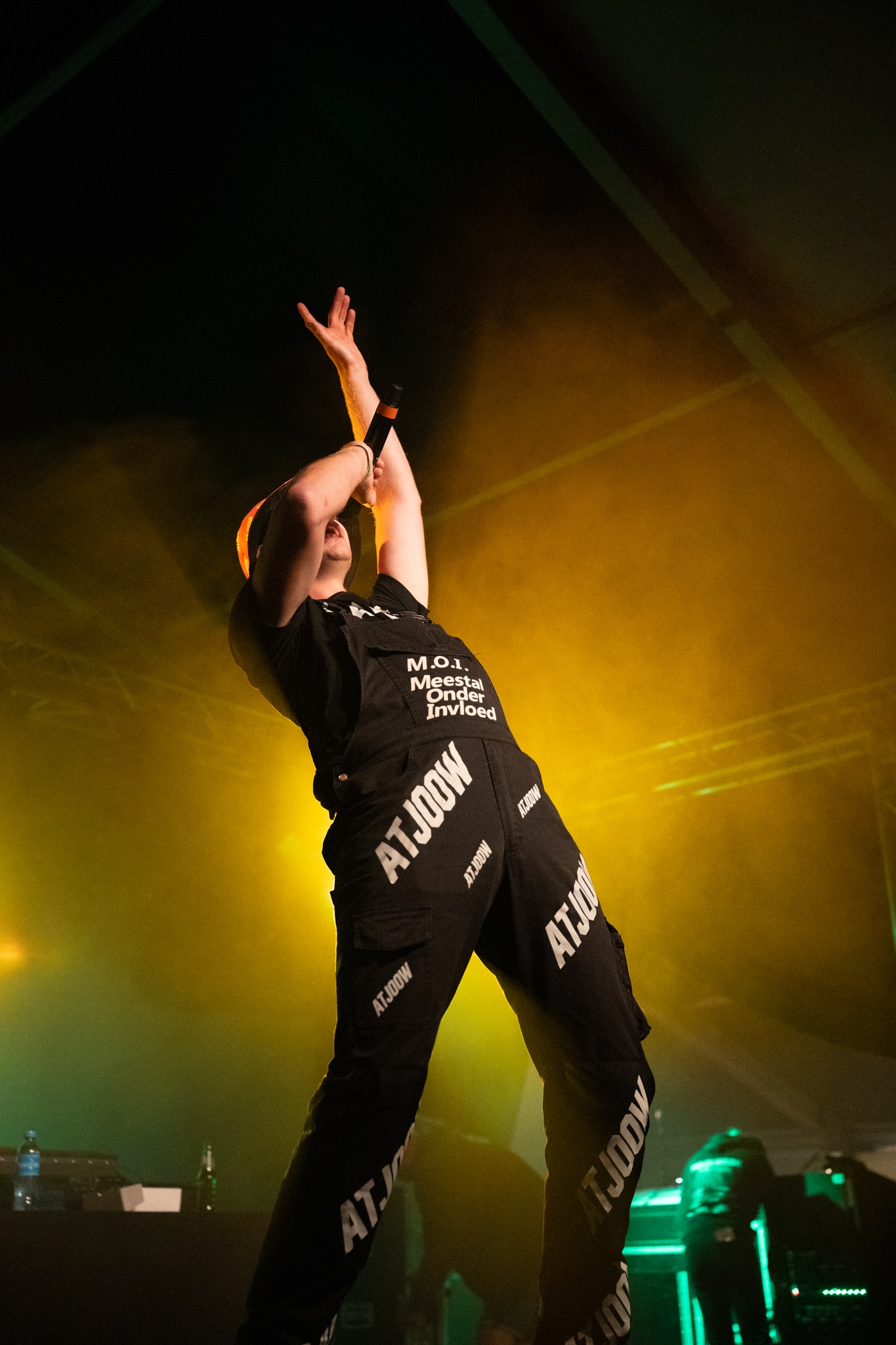 Artist leaning back in warm yellow stage light