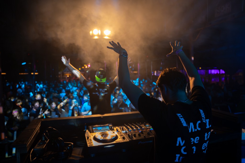 Both performers from behind facing a cheering crowd with arms raised