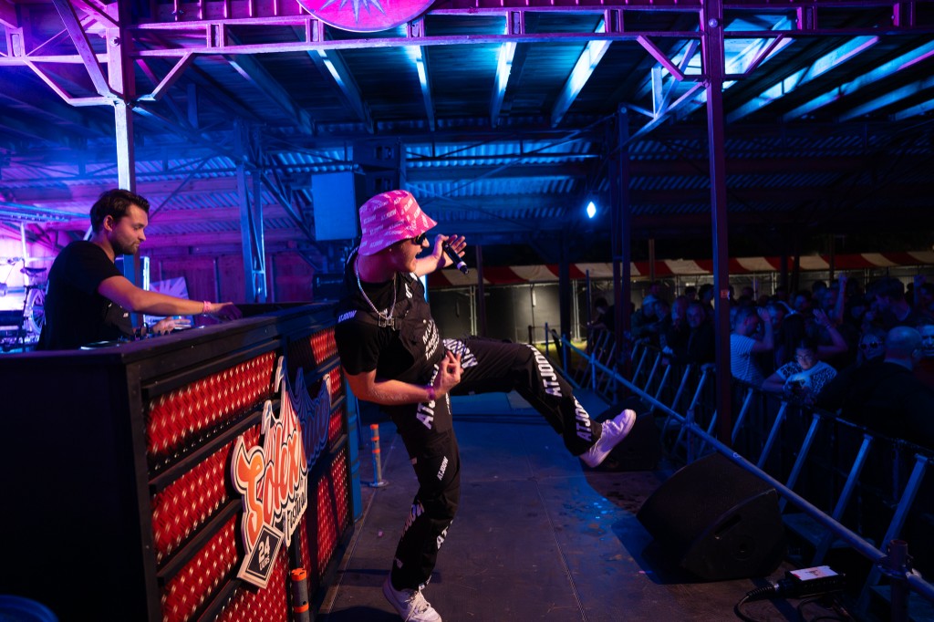 Performer on the Solexrace Festival stage in a pink ATJOOW hat