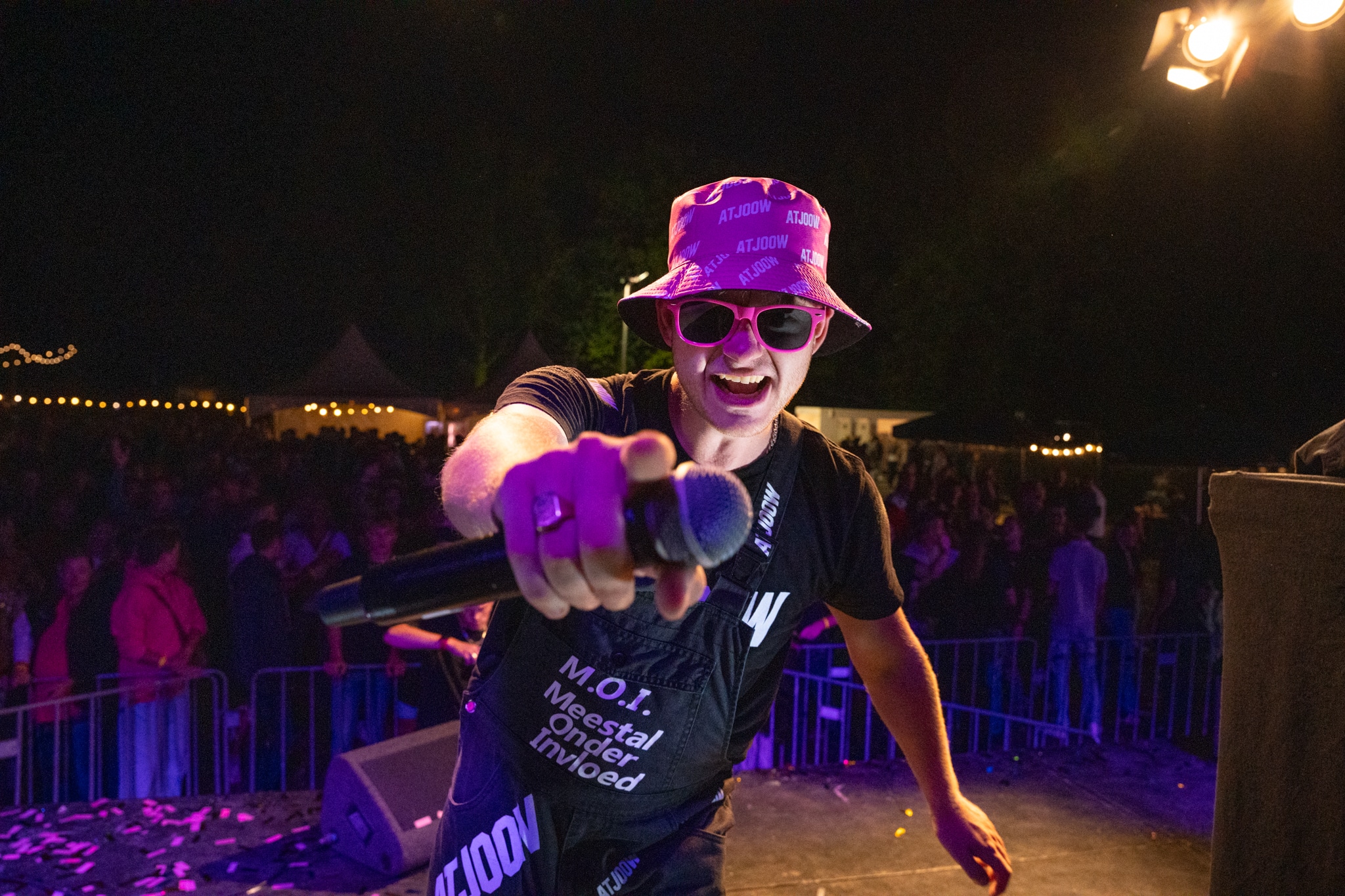 Artist smiling into the camera with microphone held toward the lens